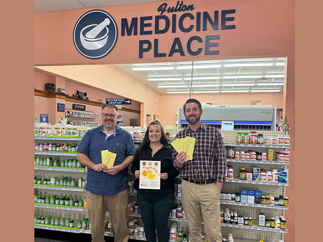 From left: Duck Derby Chair and Past President David Guyer, President Melissa Champion, and Lion Zach Merry with derby tickets and a poster promoting this year’s event.