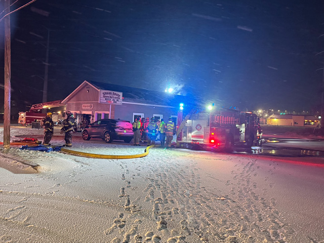 Exterior of Cheap Seats on a snowy evening with fire trucks on scene