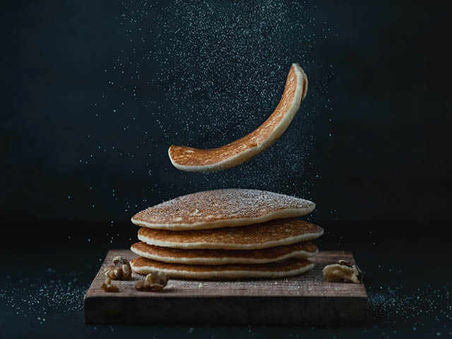 Pancakes on a cutting board with powdered sugar on top