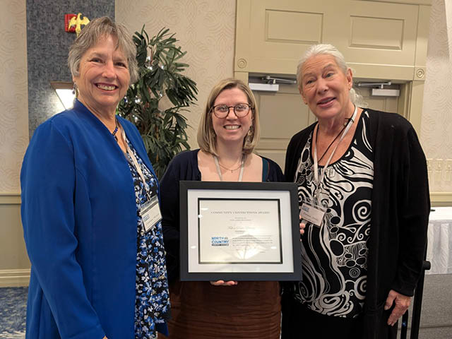 Carolyn Mosier, Caroline Chatterton, and Donna Jones pose with the award