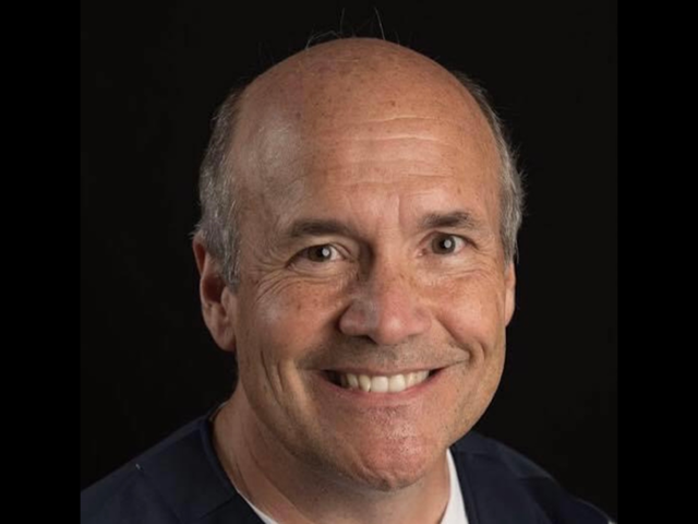 A headshot of a balding white man