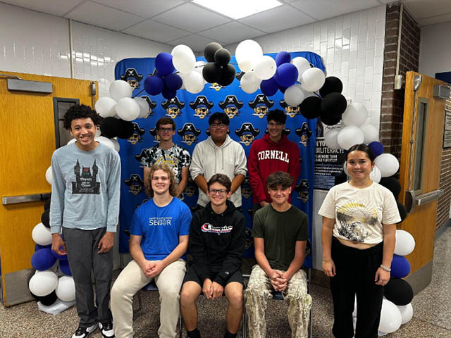 Honorees in front of a Bucs banner and balloon arch