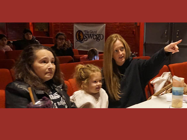 Pictured are the Oswego Players’ Director (Jennifer Hitchcock – r) and Stage Manager (Angella Bandla – l) discussing character blocking for the forthcoming production of “The Best Christmas Pageant Ever” under the watchful eye of Charlotte Hitchcock (4).