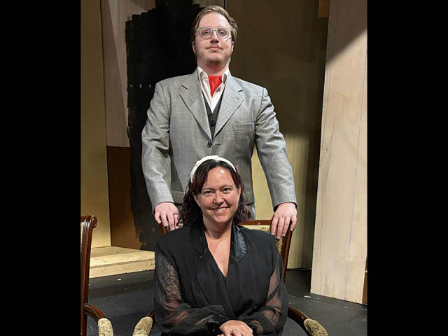 Pictured from left to right, seated Mrs. Bradman played by Jennifer Waugh and standing Dr Bradman played by Arlo Olson.
