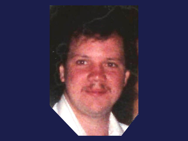 A smiling white man with a mustache