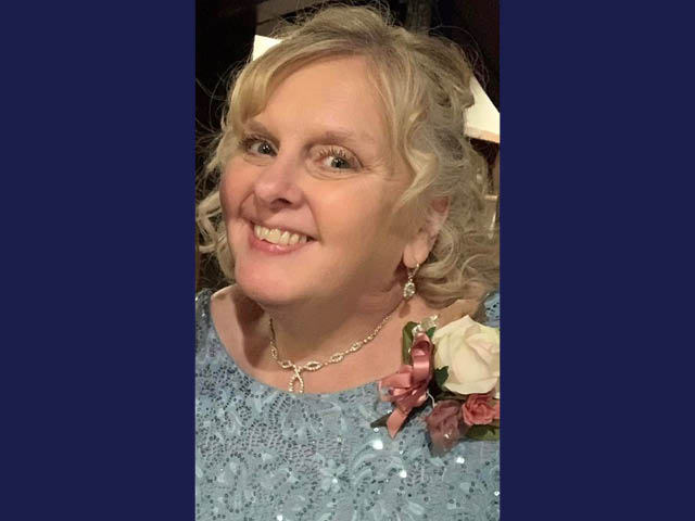 A smiling white woman with shoulder-length blonde hair