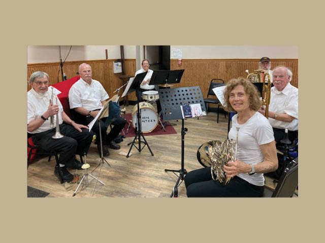 Six musicians with their instruments in a room with wooden flooring