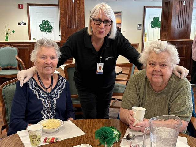 Three women in front of a table set with soup and ice water