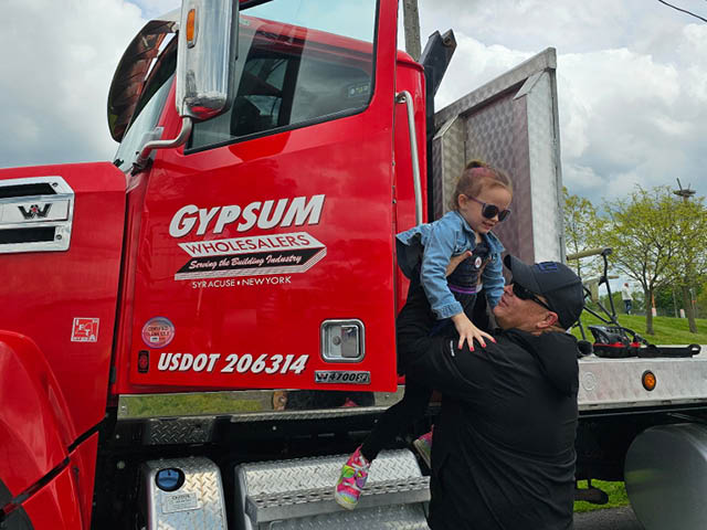 A youngster gets a hand climbing down from the cab of a Gypsum Express truck at the 2025 Big Truck Day. Gypsum Express, LTD is the title sponsor of Big Truck Day 6.