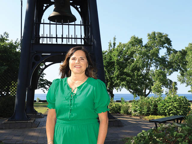 Bridget Dolbear in front of the bell at Breitbeck Park