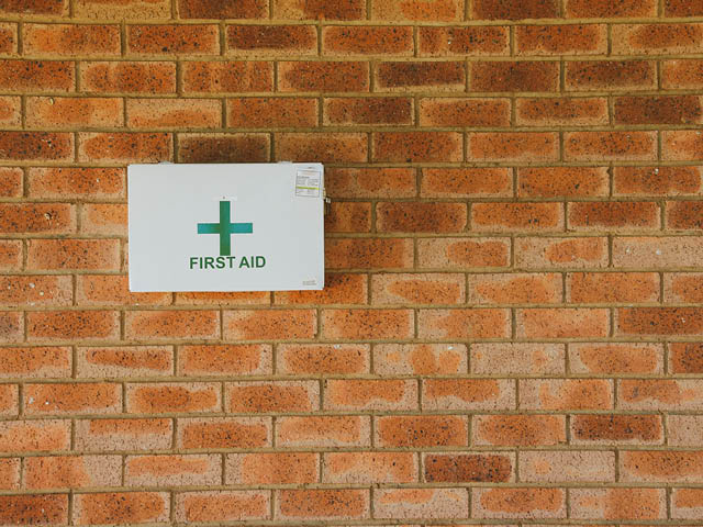 A photo of a first aid kit mounted on a brick wall
