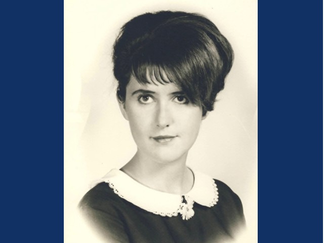 Black and white photo of young woman with short hair and bangs in soft collared shirt