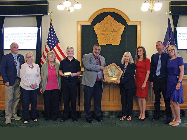 Pictured from left are Legislature Chairman James Weatherup, District 9; family friends Rhea Russell and Lois Russell; grandson David Levi Holst; Legislator John Martino, District 6, majority leader and chairman of the Legislature’s Finance and Personnel Committee; wife Patricia Holst; daughter Joeyann Holst; son Harley Holst; and daughter-in-law Natalie Holst.