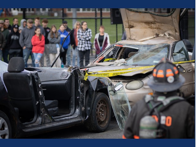 High school kids looking at a crashed car 