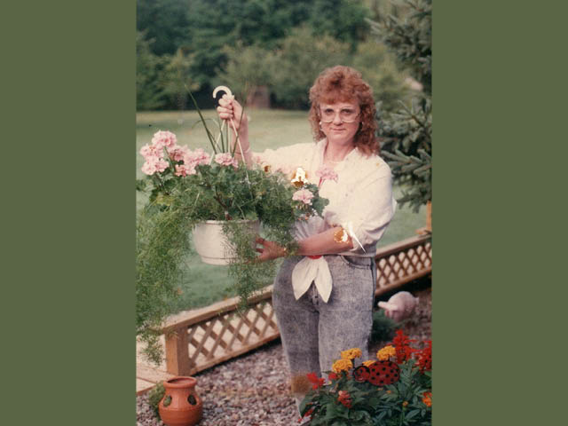 A young woman holding a hanging basket