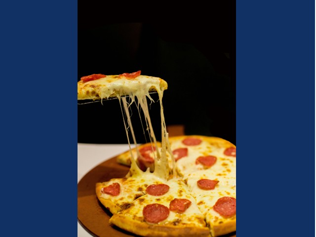One gooey cheesy pepperoni pizza on wooden oval